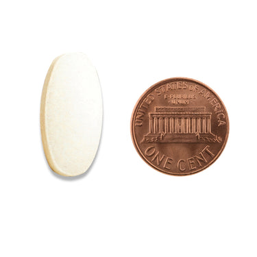 A white oval shaped tablet being compared to the size of a penny