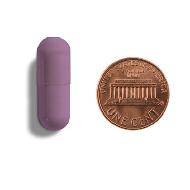 A purple capsule being compared to the size of a penny