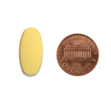 A yellow tablet being compared to the size of a penny