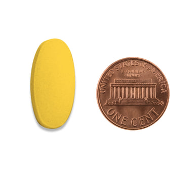 A yellow tablet being compared to the size of a penny