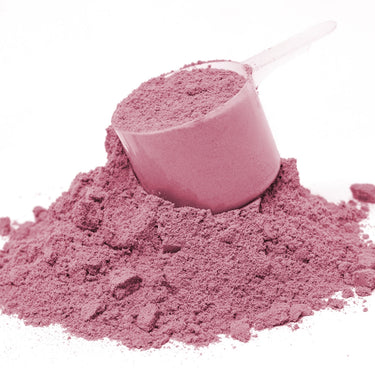 A clear scoop filled with pink powder on top of a mound of D-Mannose Complex powder