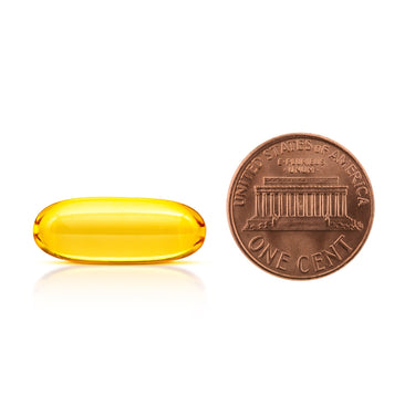 A clear yellow soft-gel capsule being compared to the size of a penny