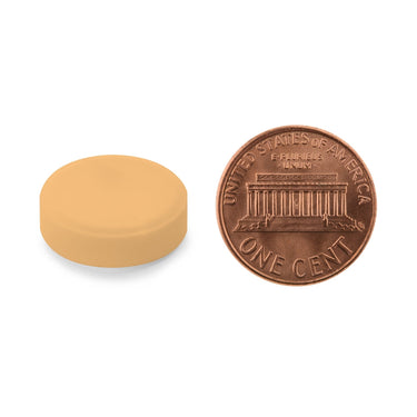 A orange tablet being compared to the size of a penny