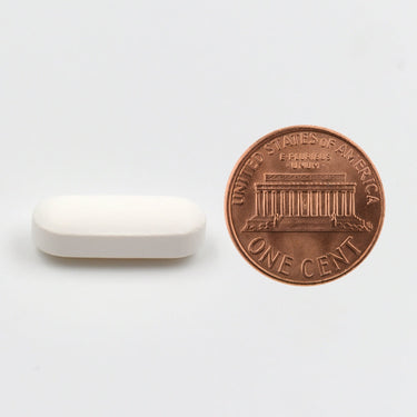 A white tablet being compared to the size of a penny