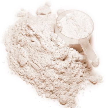 A plastic scoop filled with white powder next to  a mound of Right Whey Creamy Vanilla powder