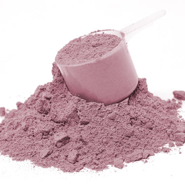 A plastic scoop filled with pink powder sitting on a mound of Spectra Red powder