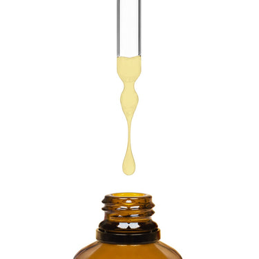 A dropper dripping lemon cream liquid into an amber bottle