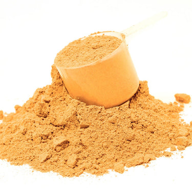 A clear scoop filled with orange powder on top of a mound of Fizzy Mag™ powder